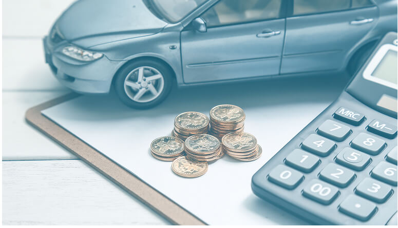 coche al lado de monedas y calculadora para saber cuanto se cobra por un accidente de tráfico